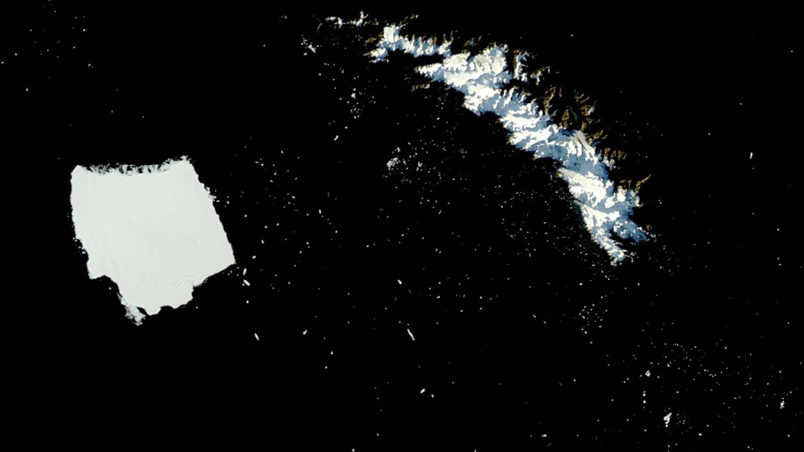 A satellite photo of a giant iceberg next to an island with hundreds of smaller icebergs surrounding the pair