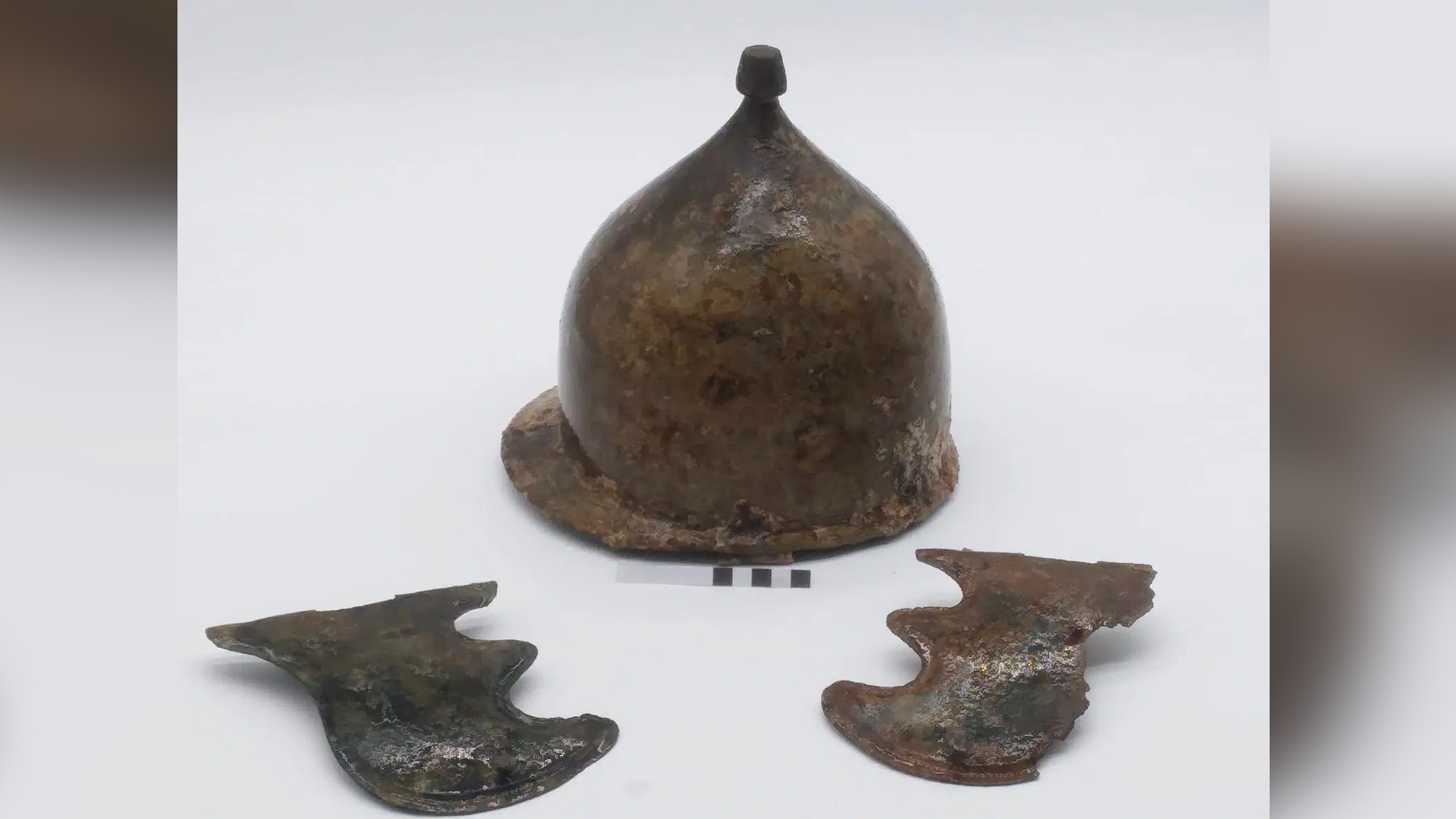 a bronze conical helmet flanked by two cheek pieces