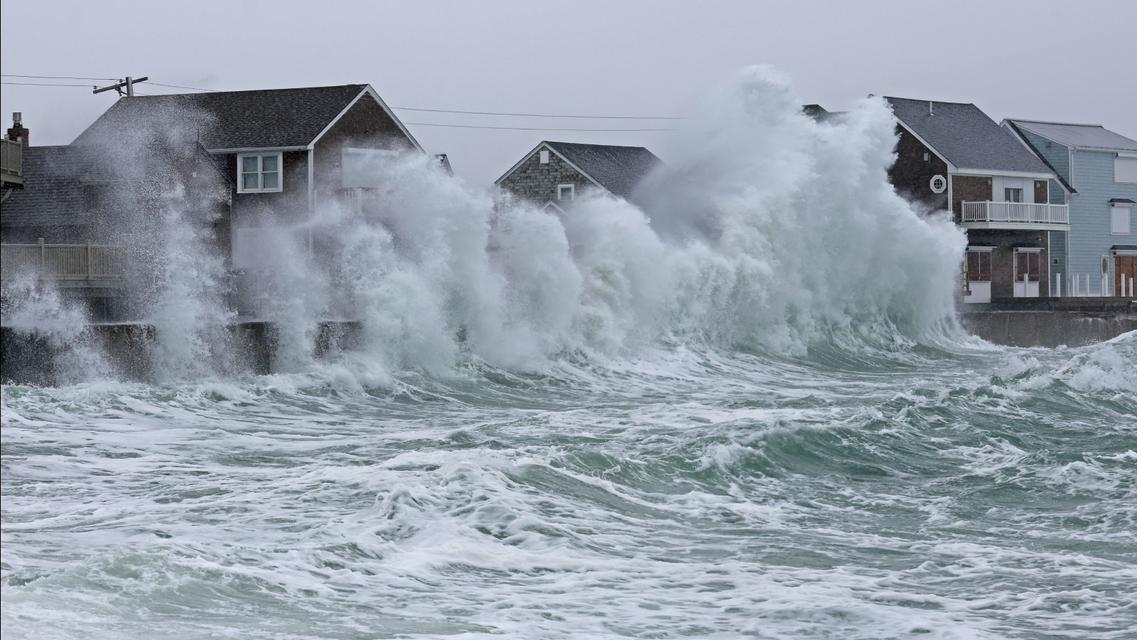 Scituate, MA - February 13: Waves crash against homes during a noreaster.